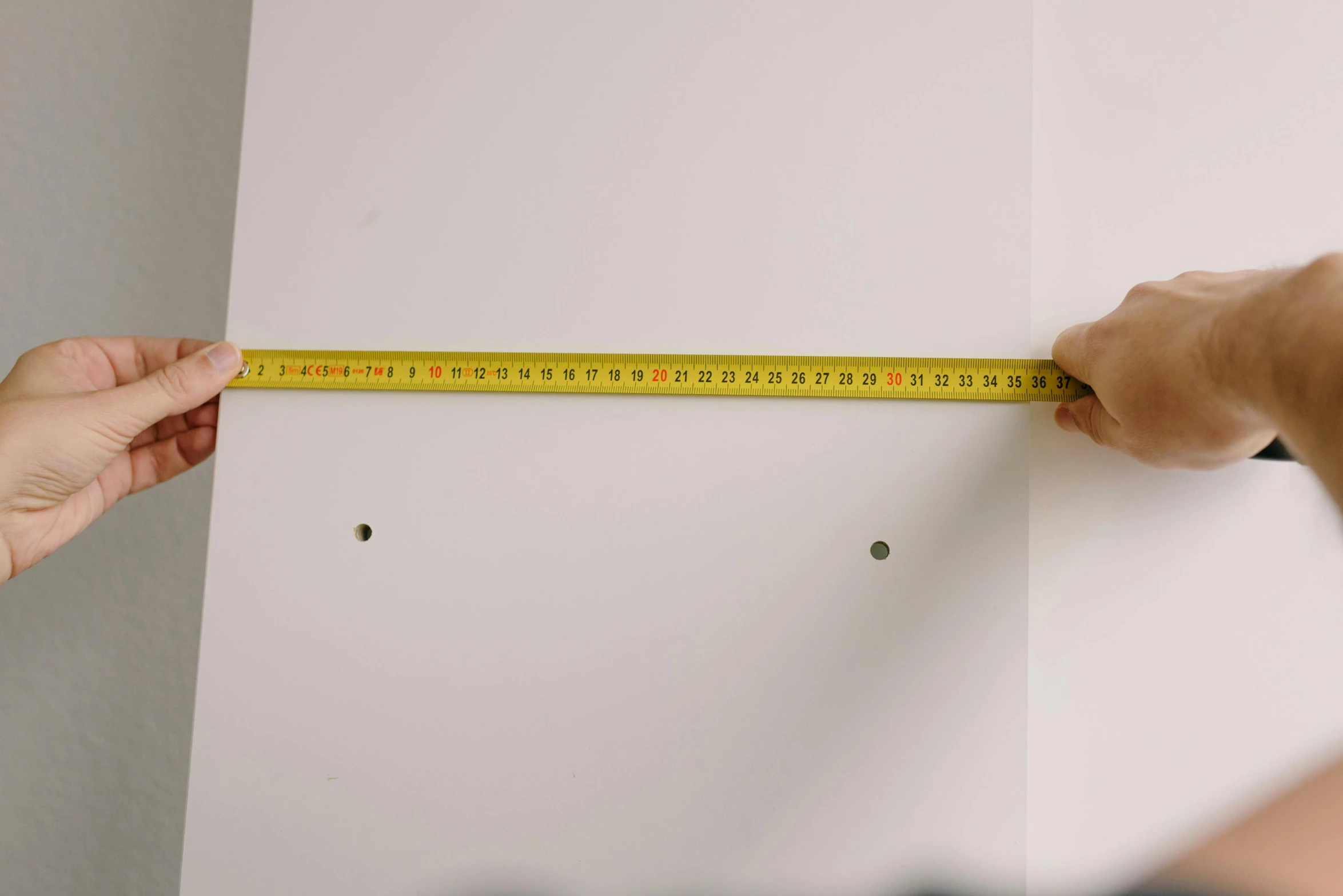 a person measuring a wall with a tape, unsplash, hyperrealism, varying dots, white backdrop, square lines, shelf