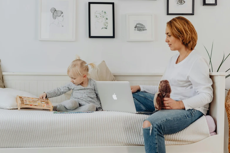 a woman and a child sitting on a bed with a laptop, by Emma Andijewska, clean design, jellycat, profile image