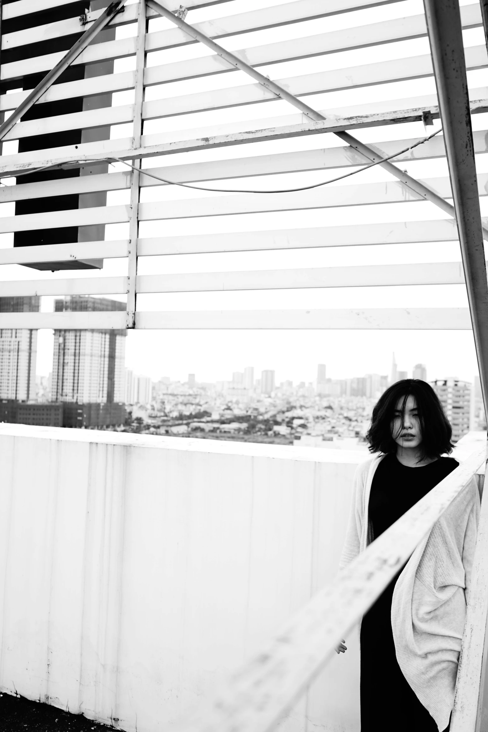 a woman standing on top of a roof next to a tall building, a black and white photo, inspired by Ai-Mitsu, finn wolfhard, hong june hyung, ryuichi sakamoto, :: morning