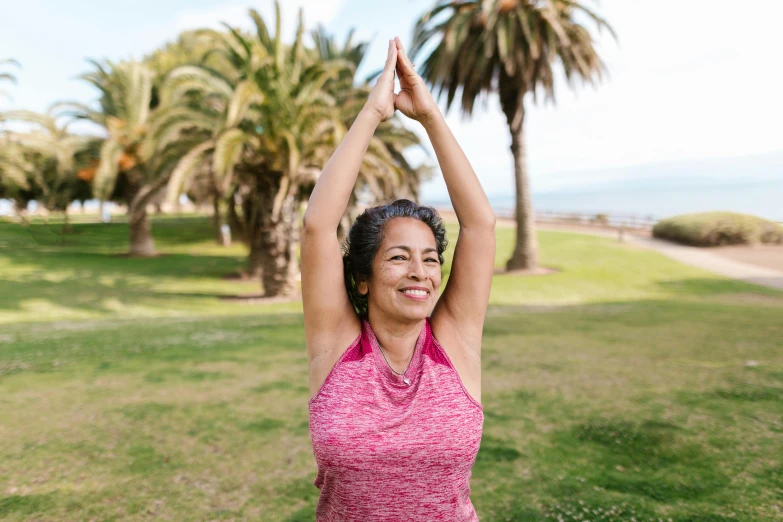 a woman stretching in a park with palm trees in the background, pexels contest winner, figuration libre, waving and smiling, avatar image, sweat and labour, half - length photo