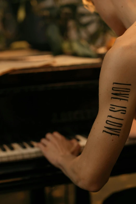 a man with a tattoo on his arm playing a piano, a tattoo, inspired by Nan Goldin, trending on pexels, lgbtq, slide show, promotional image, woman