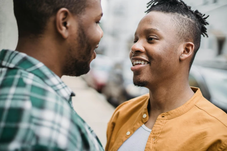 a couple of men standing next to each other, trending on pexels, smiling at each other, essence, queer, realistic »