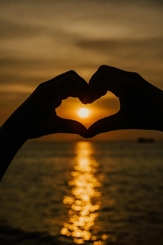 a person making a heart shape with their hands, by Matt Cavotta, pexels, romanticism, golden hour in boracay, scientific photo, large)}], small heart - shaped face