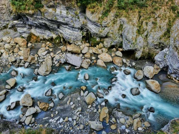 a river flowing through a lush green forest filled with rocks, by Muggur, pexels contest winner, hurufiyya, blue glacier, new zealand, structural geology, taiwan