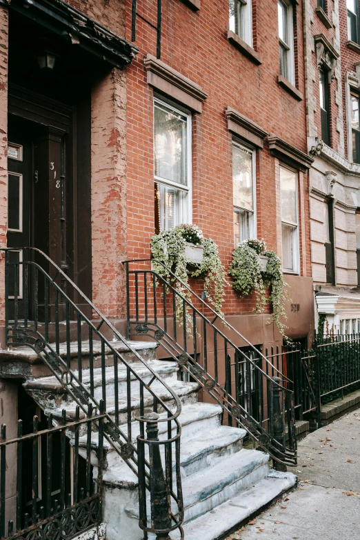 a couple of stairs going up the side of a building, by Nina Hamnett, trending on unsplash, harlem renaissance, quaint village, romantic greenery, holiday season, new york buildings