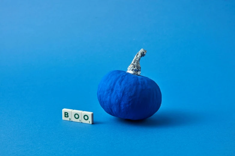 a blue pumpkin sitting on top of a blue surface, an album cover, inspired by Yves Klein, unsplash contest winner, magic realism, miniature origami figurine, alphabet soup, trending on dezeen, third trimester