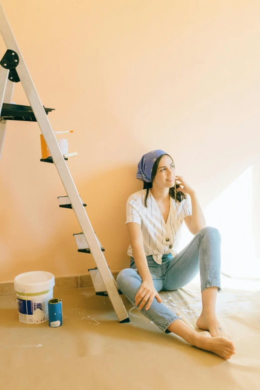 a woman sitting on the floor talking on a cell phone, a painting, trending on pexels, ladders, pastel color, distressed paint, promotional image