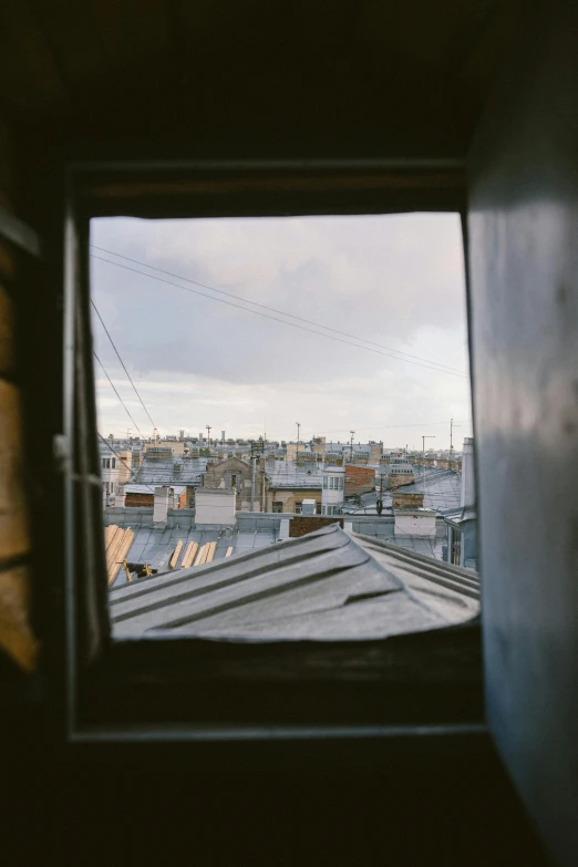 a view of a city through a window, a polaroid photo, trending on unsplash, paris school, shanty town, low - angle shot from behind, wide film still, shot from roofline