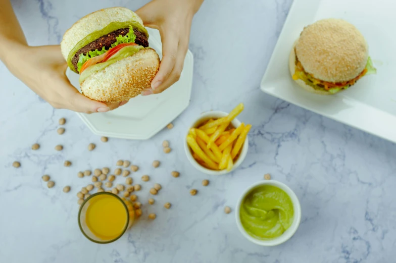 a person holding a hamburger and french fries, by Julia Pishtar, pexels contest winner, greens), bao pnan, background image, food particles