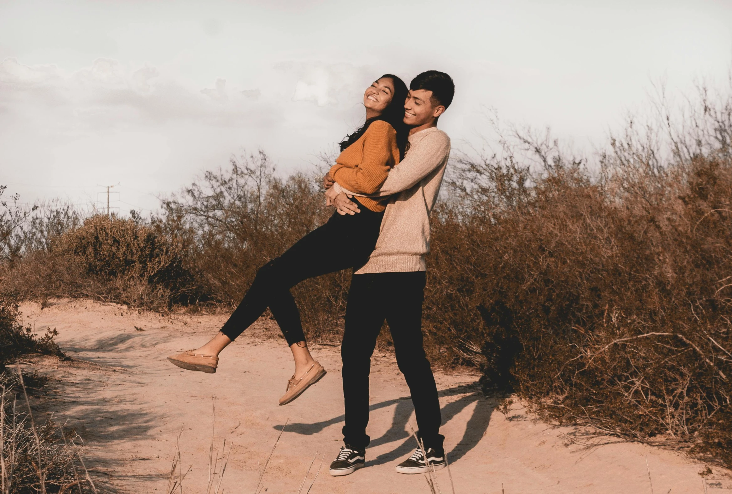 a man carrying a woman on his back, pexels contest winner, pokimane, standing in sand, full body length shot, riyahd cassiem