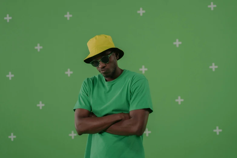 a man in a green shirt and a yellow hat, by Nyuju Stumpy Brown, trending on pexels, les nabis, avatar image, studio background, mkbhd, still from a music video