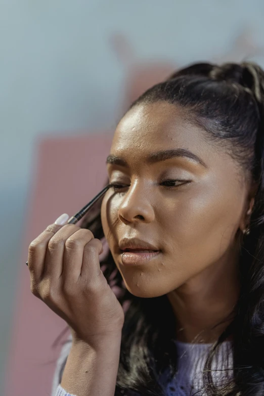 a woman holding a cell phone to her ear, an album cover, trending on pexels, hyperrealism, putting makeup on, brown skin. light makeup, cat eye, high angle close up shot