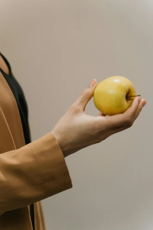 a woman holding an apple in her hand, unsplash, wearing jacket, yellowed, 15081959 21121991 01012000 4k, low detail