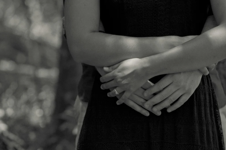 a black and white photo of a couple holding hands, by Lucia Peka, unsplash, woman holding another woman, video still, arms crossed, ignant