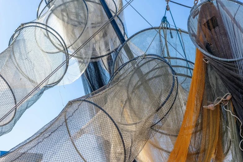 a group of fishing nets hanging from the side of a boat, an album cover, unsplash, net art, circles, frank gehry, closeup photo, promo image