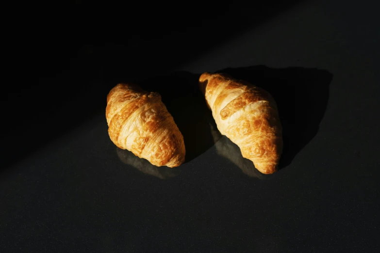 a couple of croissants sitting on top of a table, uv, fan favorite, shot with sony alpha 1 camera, hasselblatt