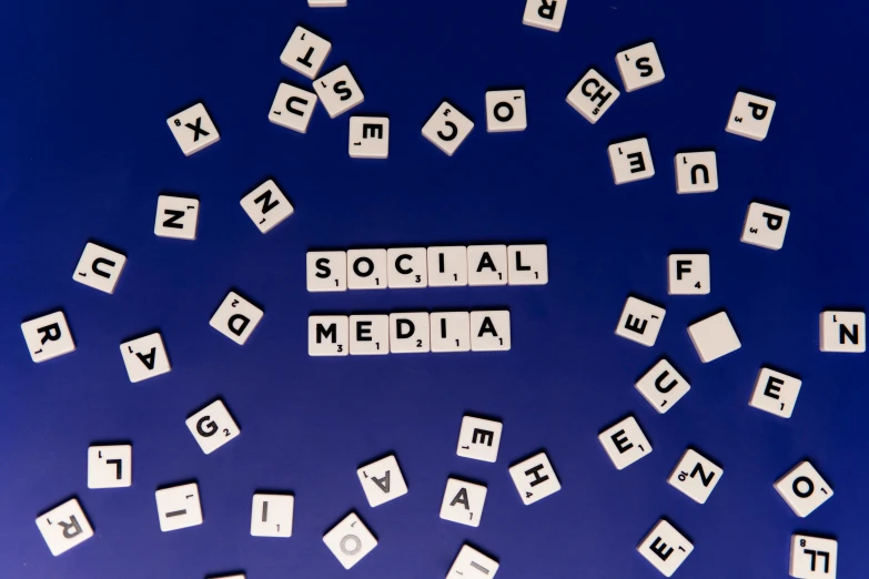 scrabbles spelling social media on a blue background, unsplash, ad image, 1 2 9 7, shot from below, nfts