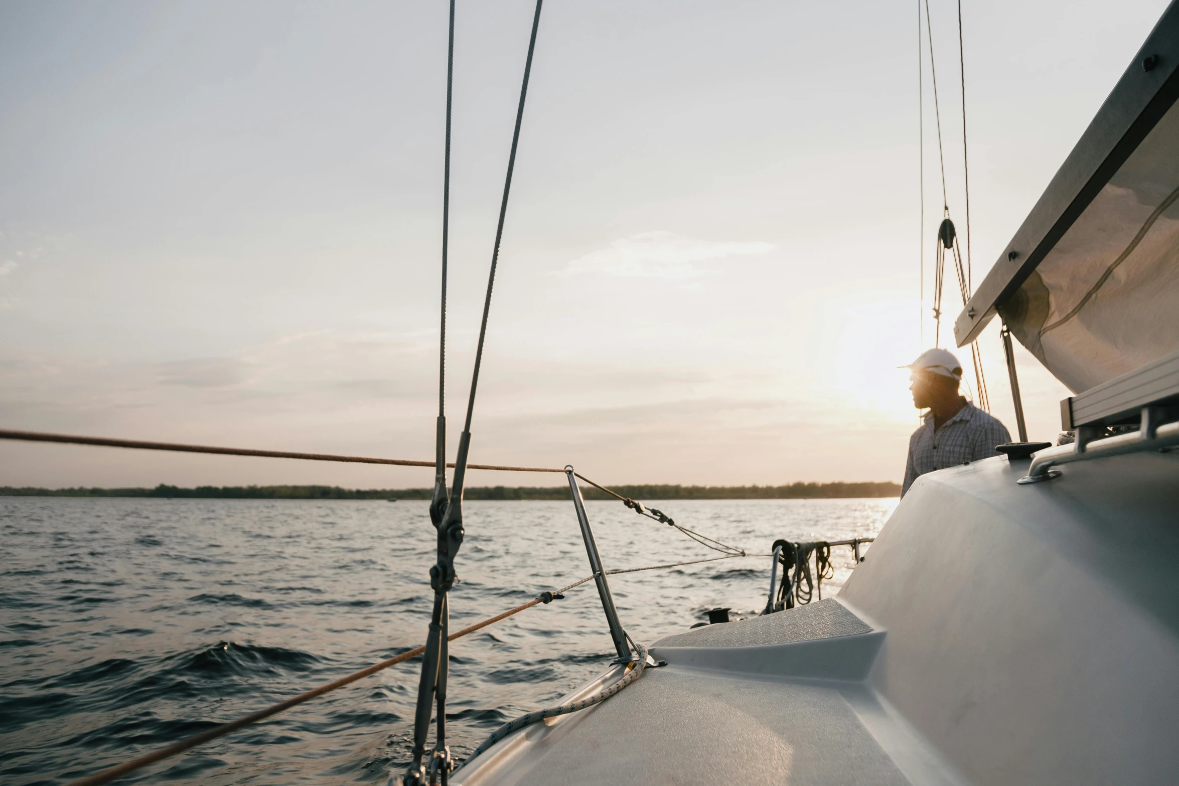 a man sitting on the bow of a sailboat, pexels contest winner, happening, early evening, instagram post, lachlan bailey, where a large