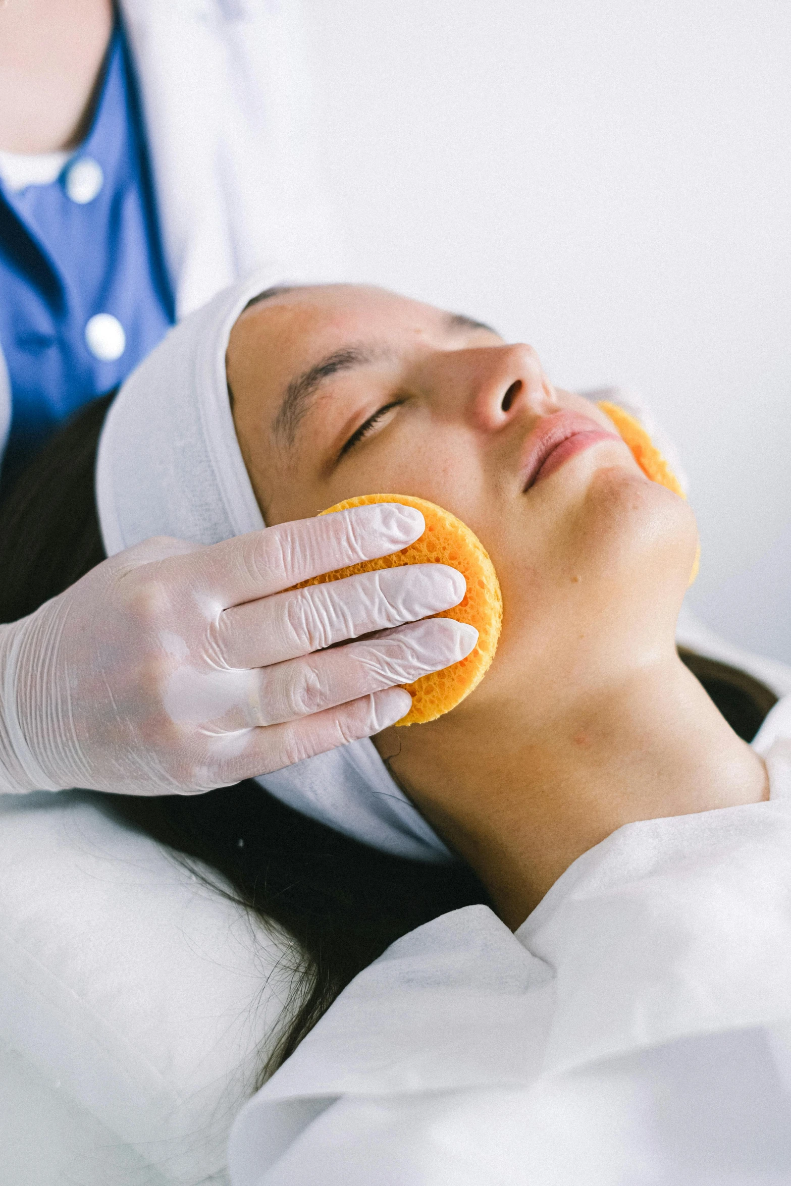 a woman getting an orange peel on her face, by Robbie Trevino, soft pads, upper body and face, square, clinical