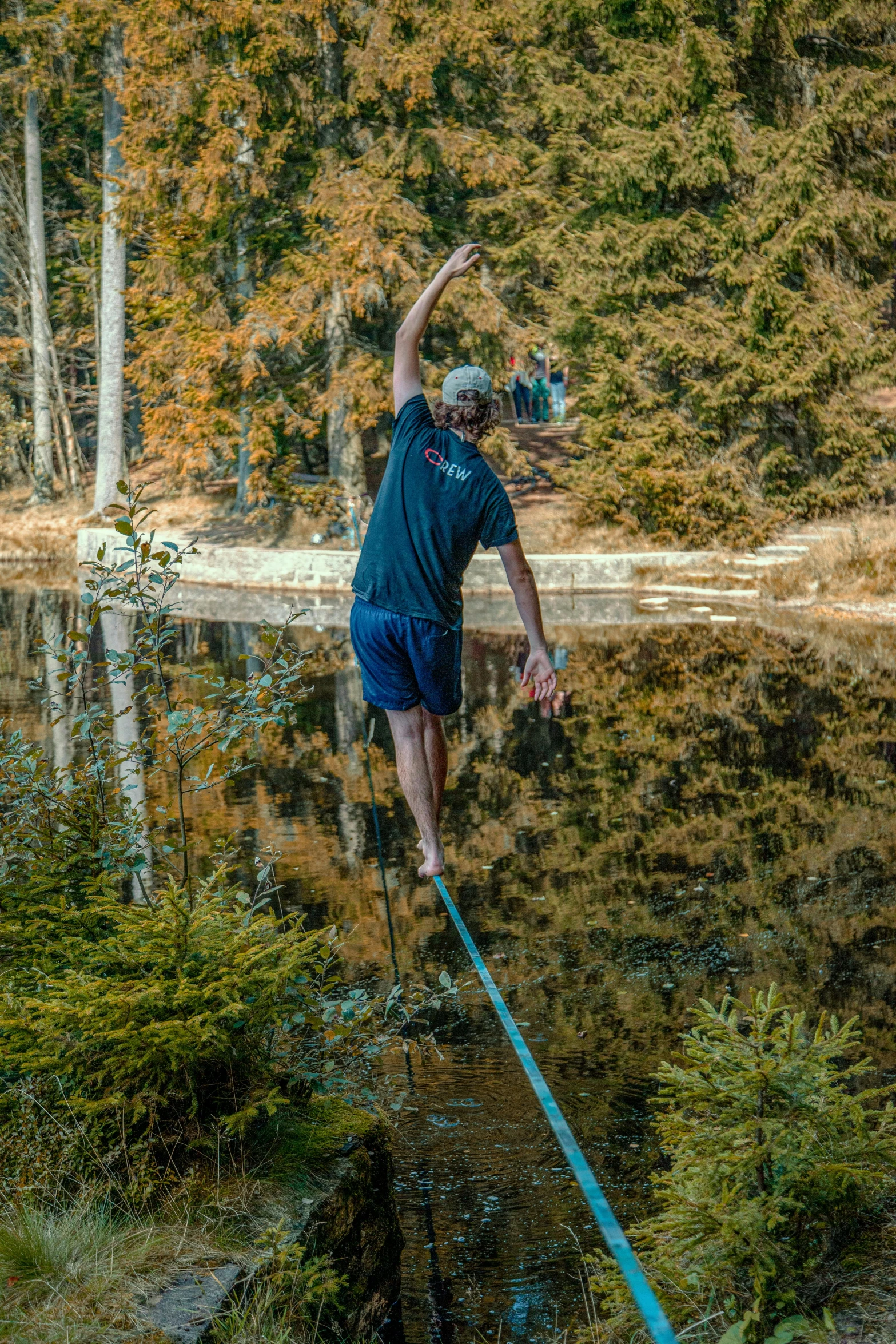 a man walking a rope across a body of water, hanging trees, pulling the move'derp banshee ', highly upvoted, outdoor