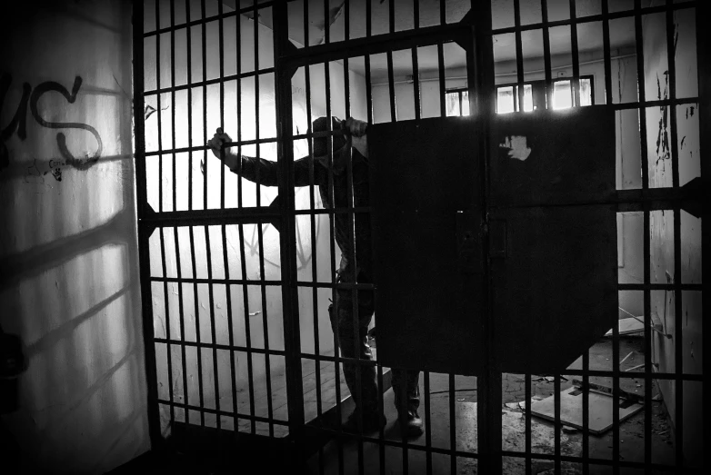 a black and white photo of a jail cell, a black and white photo, pexels, conceptual art, man standing, playing, animation still, instagram post