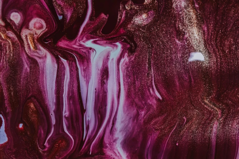 a close up of a piece of art on a table, inspired by Julian Schnabel, trending on pexels, abstract expressionism, purple liquid, maroon metallic accents, abstract human body, magical potions