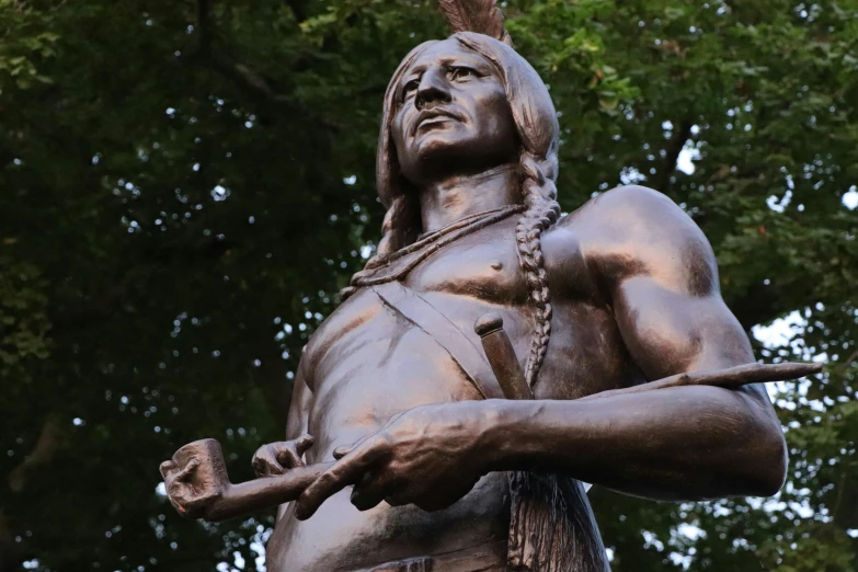a statue of a man holding a knife, inspired by George B. Bridgman, pexels contest winner, pocahontas, feathers growing from arms, parks and monuments, with a pointed chin