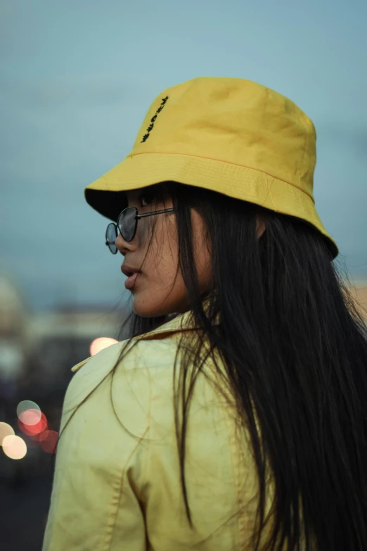 a woman with long black hair wearing a yellow hat, trending on pexels, streetwear, early evening, with sunglass, asian women