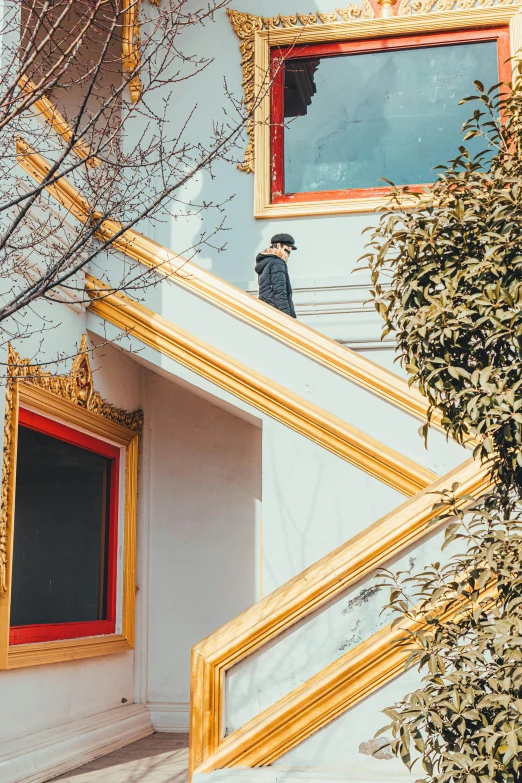 a red fire hydrant sitting in front of a building, an album cover, inspired by Ren Hang, pexels contest winner, stairway, golden windows, looking at his phone, climbing a tree