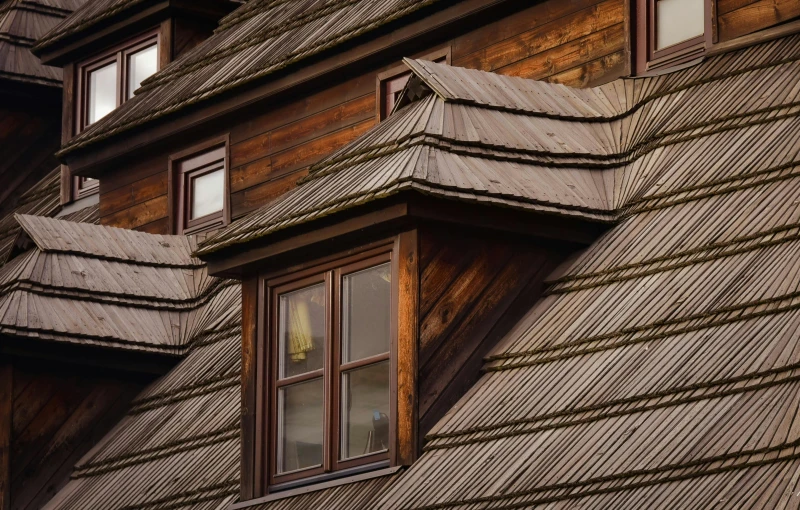 a couple of windows that are on the side of a building, by Adam Marczyński, pexels contest winner, arts and crafts movement, peaked wooden roofs, cottage close up, brown, geometrically correct