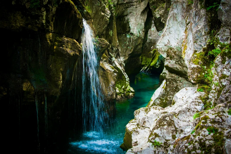 a waterfall coming out of a cave into a body of water, slovenian, deep colour, thumbnail, fan favorite