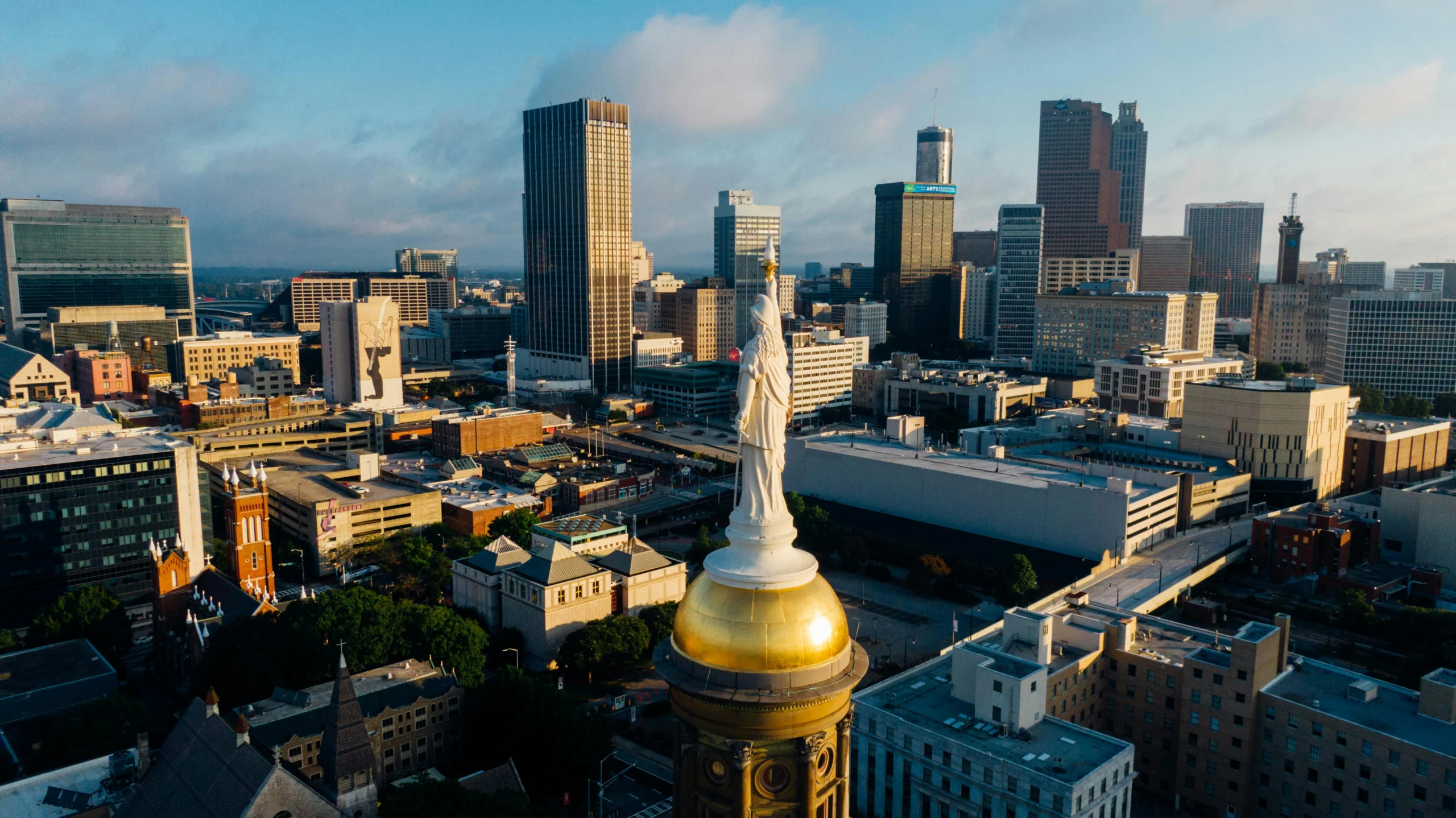 an aerial view of a city with tall buildings, by Jason Benjamin, unsplash contest winner, renaissance, neoclassical tower with dome, “ golden chalice, alabama, aerial footage