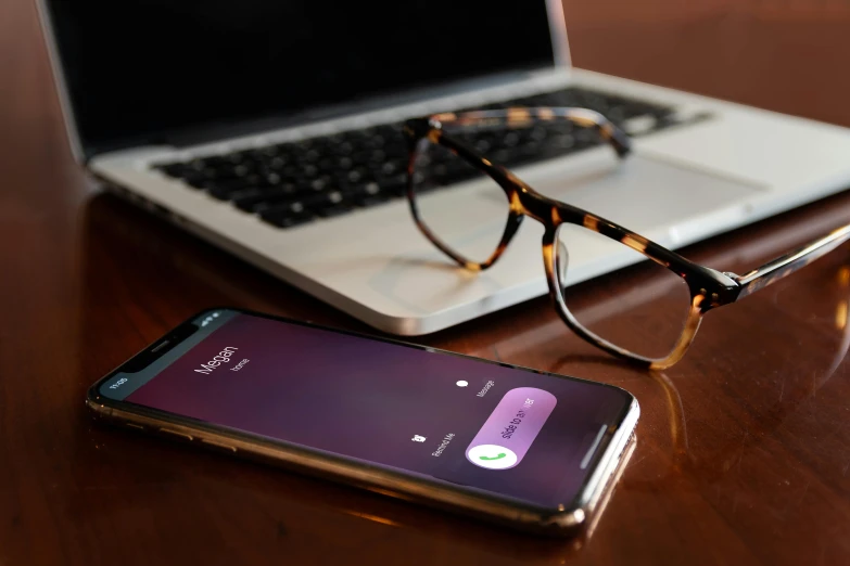 a laptop computer sitting on top of a wooden table next to a pair of glasses, a portrait, trending on pexels, corporate phone app icon, purple gradient, phone recording, mobie still