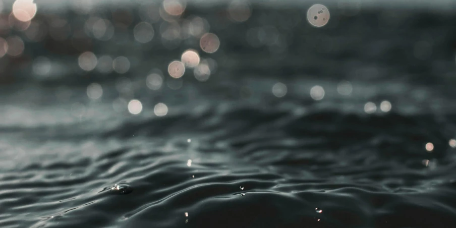 a close up of a body of water, unsplash, it is night and raining, desaturated, bubbly, maybe small waves