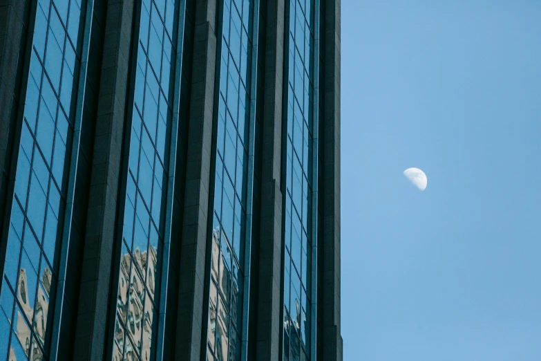 a very tall building with a half moon in the sky, unsplash contest winner, glossy reflections, shot on 1 5 0 mm, taken in the late 2010s, at high noon