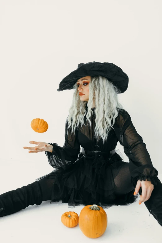 a woman in a witch costume sitting on the floor with pumpkins, trending on pexels, rococo, ava max, black on white background, an oversized beret, black and orange colour palette