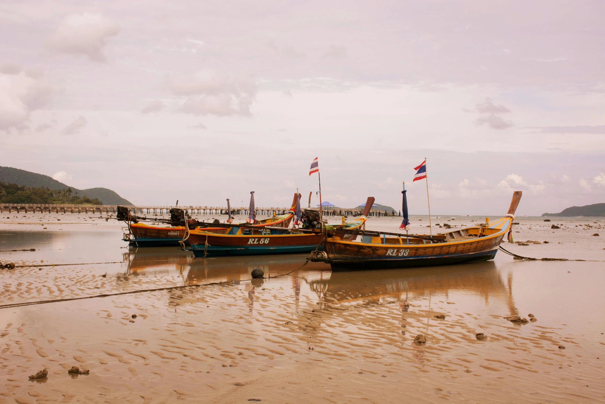 a couple of boats sitting on top of a sandy beach, unsplash contest winner, thai, avatar image, three masts, school of fishes