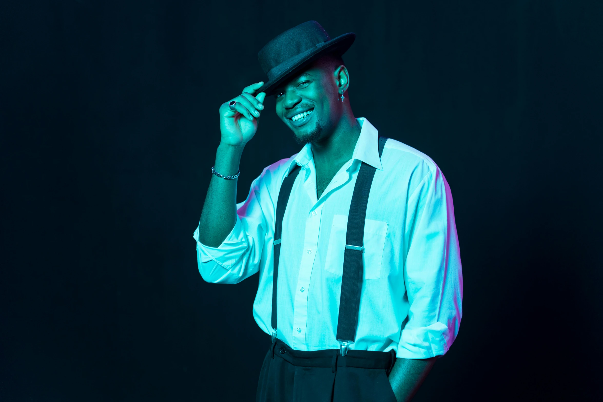 a man in a hat and suspenders talking on a cell phone, an album cover, inspired by Theo Constanté, pexels, happening, posing in dramatic lighting, while smiling for a photograph, ( ( dark skin ) ), model posing