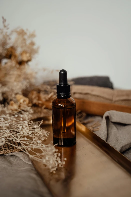 a bottle of essential oil sitting on a table, unsplash, brown, oil in canvas, detailed product image, handcrafted