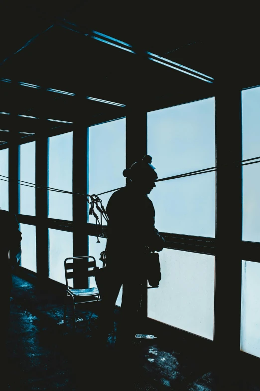 a silhouette of a man standing in front of a window, scaffolding, unsplash photography, cleaning future, chairlifts