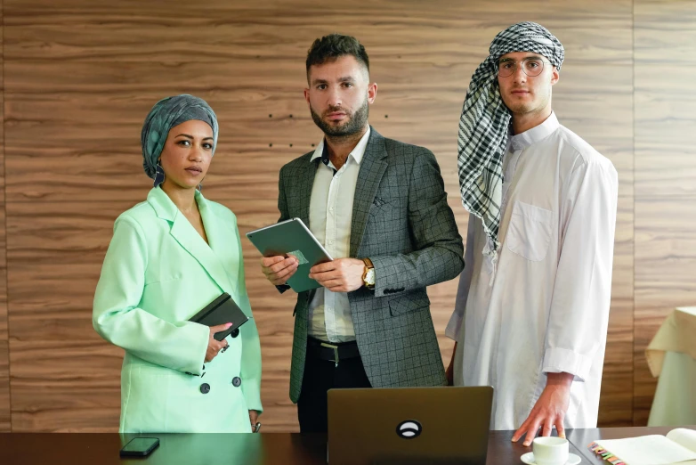 two men and a woman standing in front of a laptop, by Ismail Acar, pexels contest winner, hurufiyya, dressed in expensive clothes, middle eastern skin, in the office, scumbled