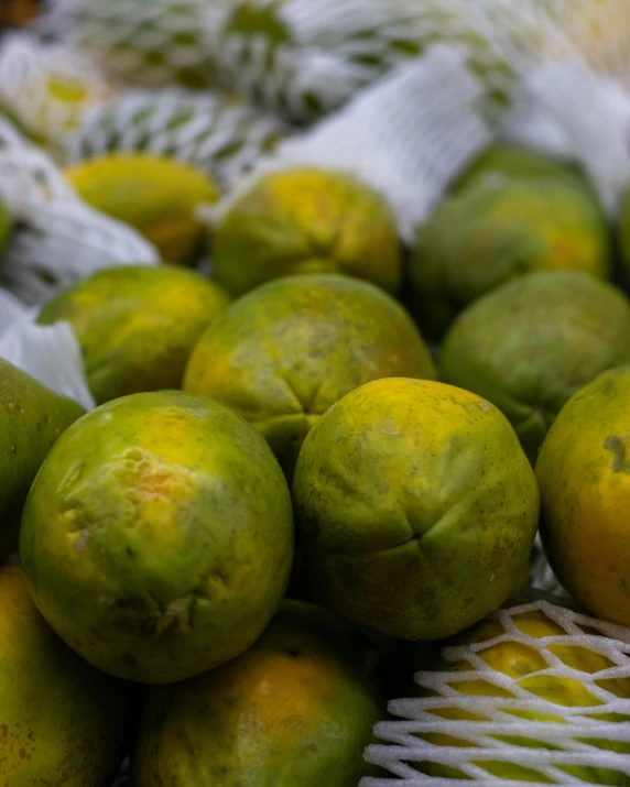 a pile of lemons sitting on top of a table, greenish skin, thumbnail, battered, peruvian looking