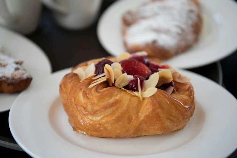 a pastry sitting on top of a white plate, inspired by Richmond Barthé, unsplash, fan favorite, breakfast buffet, melbourne, raspberry