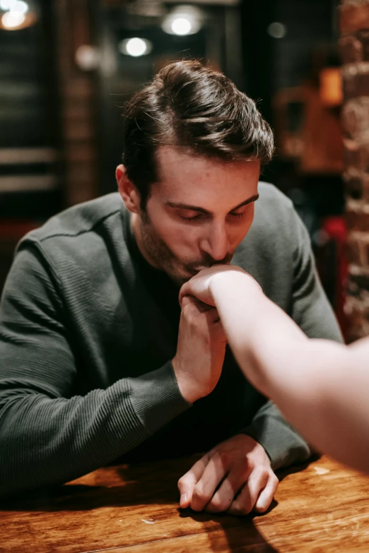 a man and a woman sitting at a table, trending on pexels, hand over mouth, focus on his foot, licking out, josh black