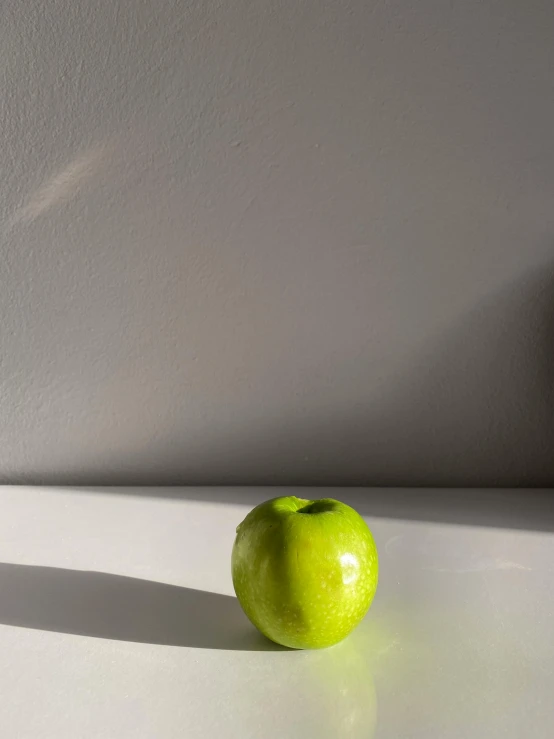 a green apple sitting on top of a white table, by Gavin Hamilton, mid morning lighting, an olive skinned, by greg rutkowski, 🍸🍋