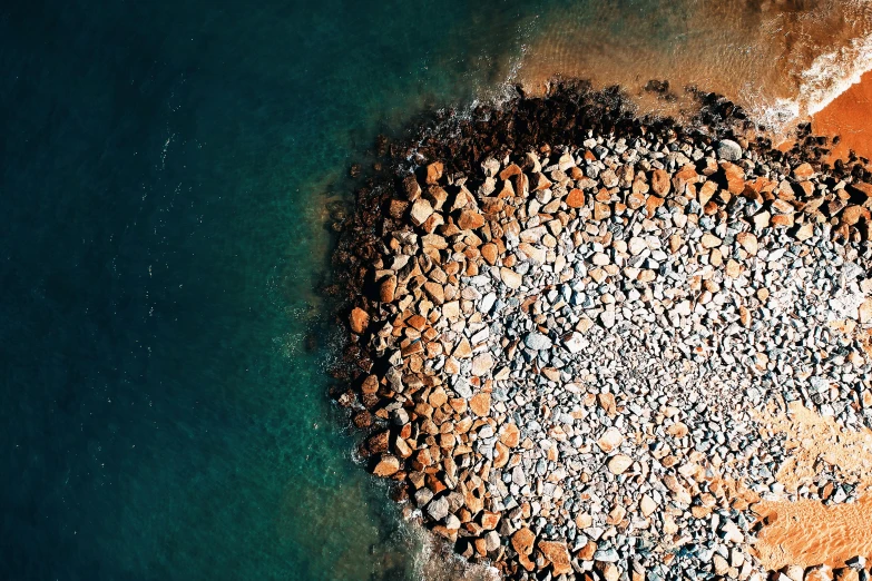 a bird's eye view of a rocky beach, an album cover, unsplash contest winner, ((rocks)), brown, billions of details, round-cropped
