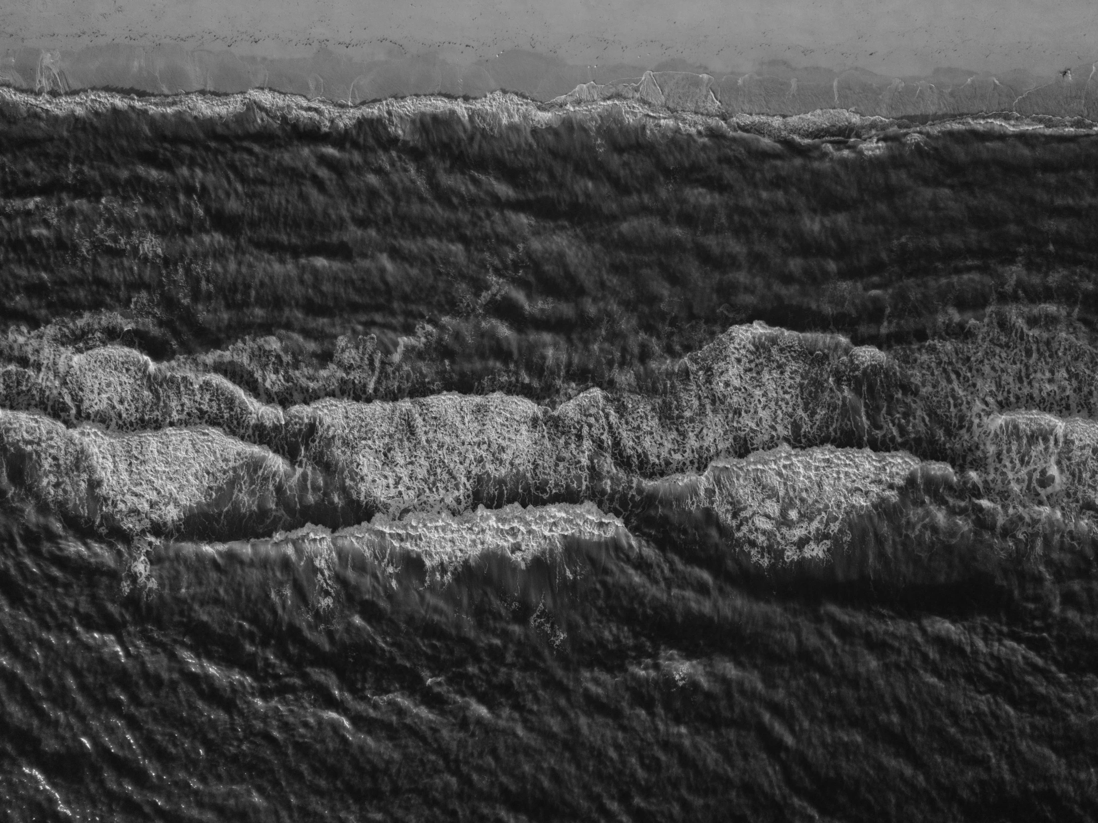 a herd of sheep standing on top of a lush green field, a microscopic photo, by Jan Konůpek, conceptual art, in rough seas with large waves, grainy black and white footage, shiny layered geological strata, taken from a plane