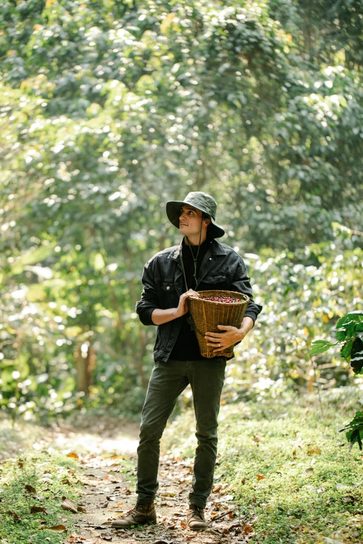 a man standing in the middle of a forest holding a basket, orelsan, coffee, production photo, black