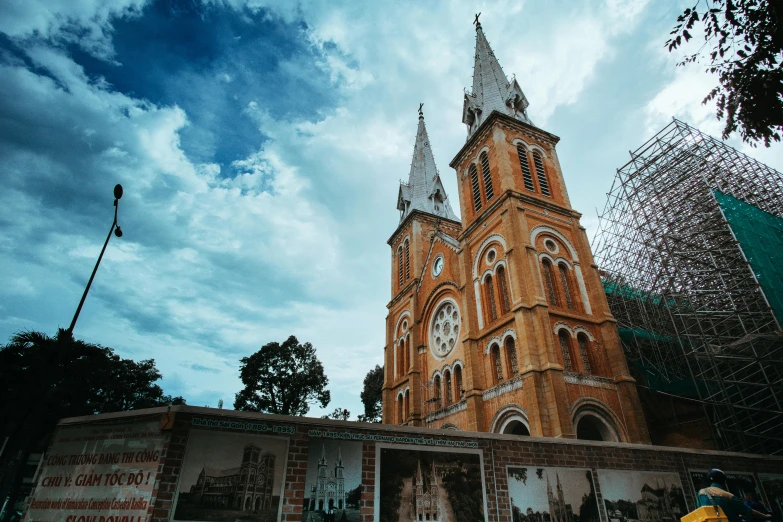 a person riding a bike in front of a church, by Sam Dillemans, unsplash contest winner, hyperrealism, vietnam, under construction, square, marilyn church h