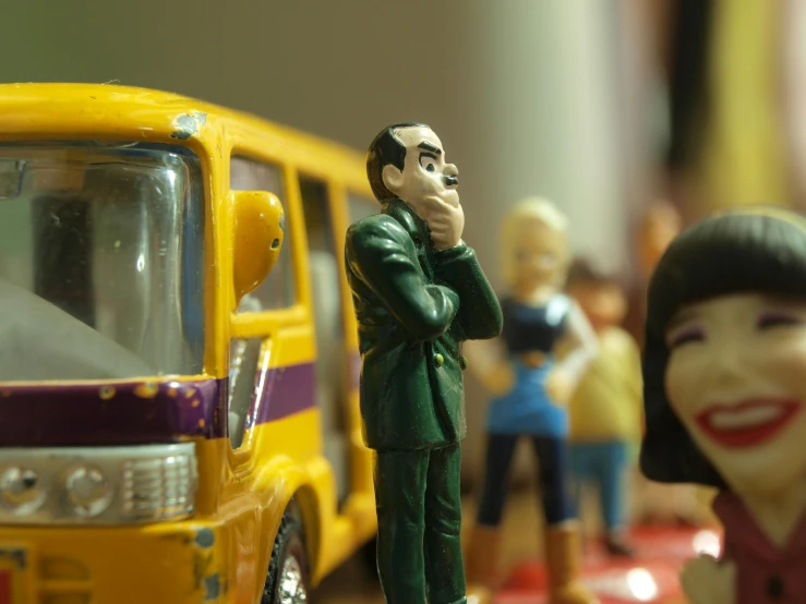 a figurine of a man talking on a cell phone next to a toy bus, a cartoon, pexels contest winner, figuration libre, several dolls in one photo, junji murakami, cars, plasticine